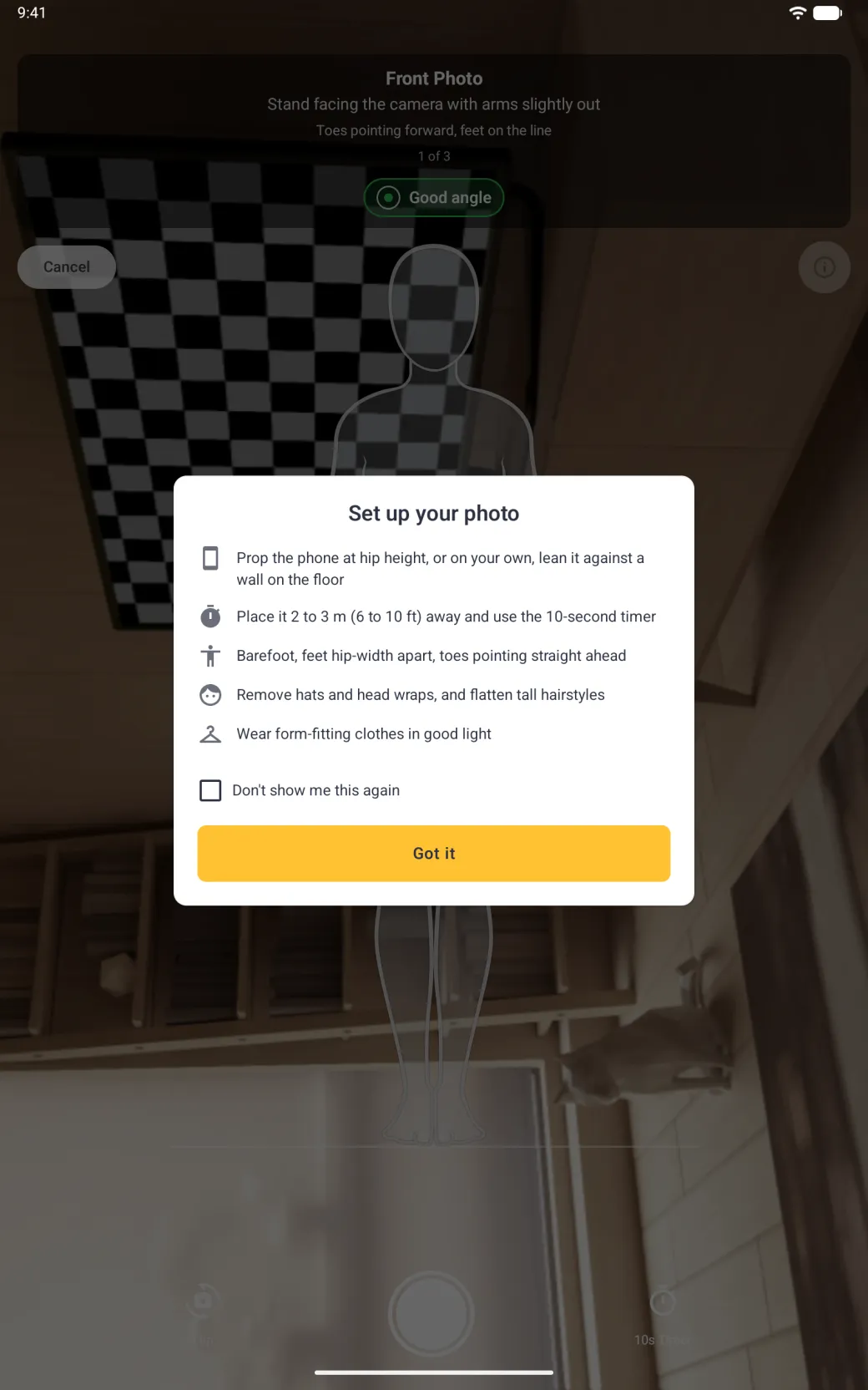 A Set up your photo card centred over the dimmed full-screen camera screen, below the Front Photo banner with its green Good angle pill and the Cancel and i buttons, with five tips each beside an icon (prop the phone at hip height or on your own lean it against a wall on the floor, place it 2 to 3 m (6 to 10 ft) away and use the 10-second timer, barefoot with feet hip-width apart and toes pointing straight ahead, remove hats and head wraps and flatten tall hairstyles, wear form-fitting clothes in good light), an unticked Don't show me this again checkbox and a gold Got it button, with the body guide outline, Flip, the shutter and 10s Timer dimmed behind it.