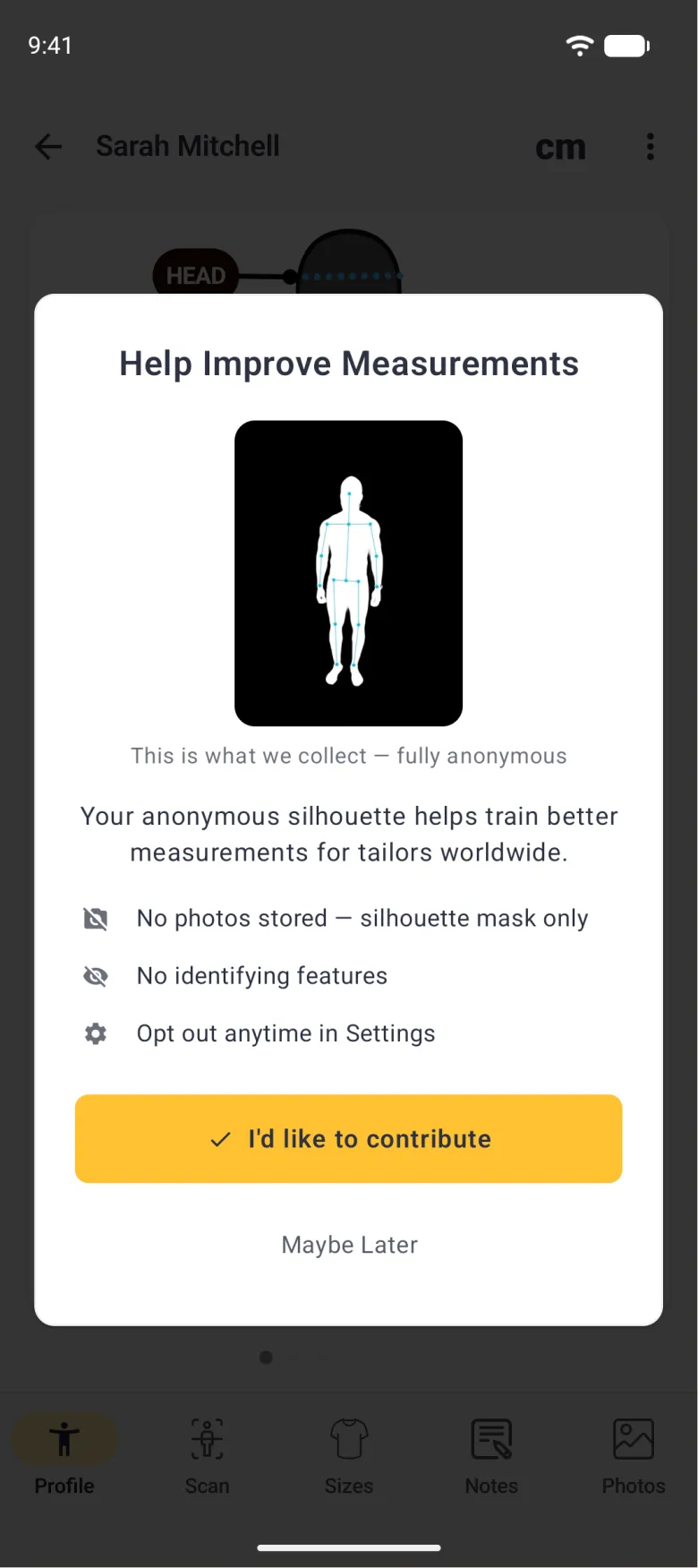 A white dialog over the dimmed Sarah Mitchell profile titled Help Improve Measurements, with a white body outline and cyan pose points on a black panel, the caption This is what we collect, fully anonymous, the line Your anonymous silhouette helps train better measurements for tailors worldwide, three grey-icon points reading No photos stored, silhouette mask only, No identifying features and Opt out anytime in Settings, a gold I'd like to contribute button with a tick and a grey Maybe Later link.