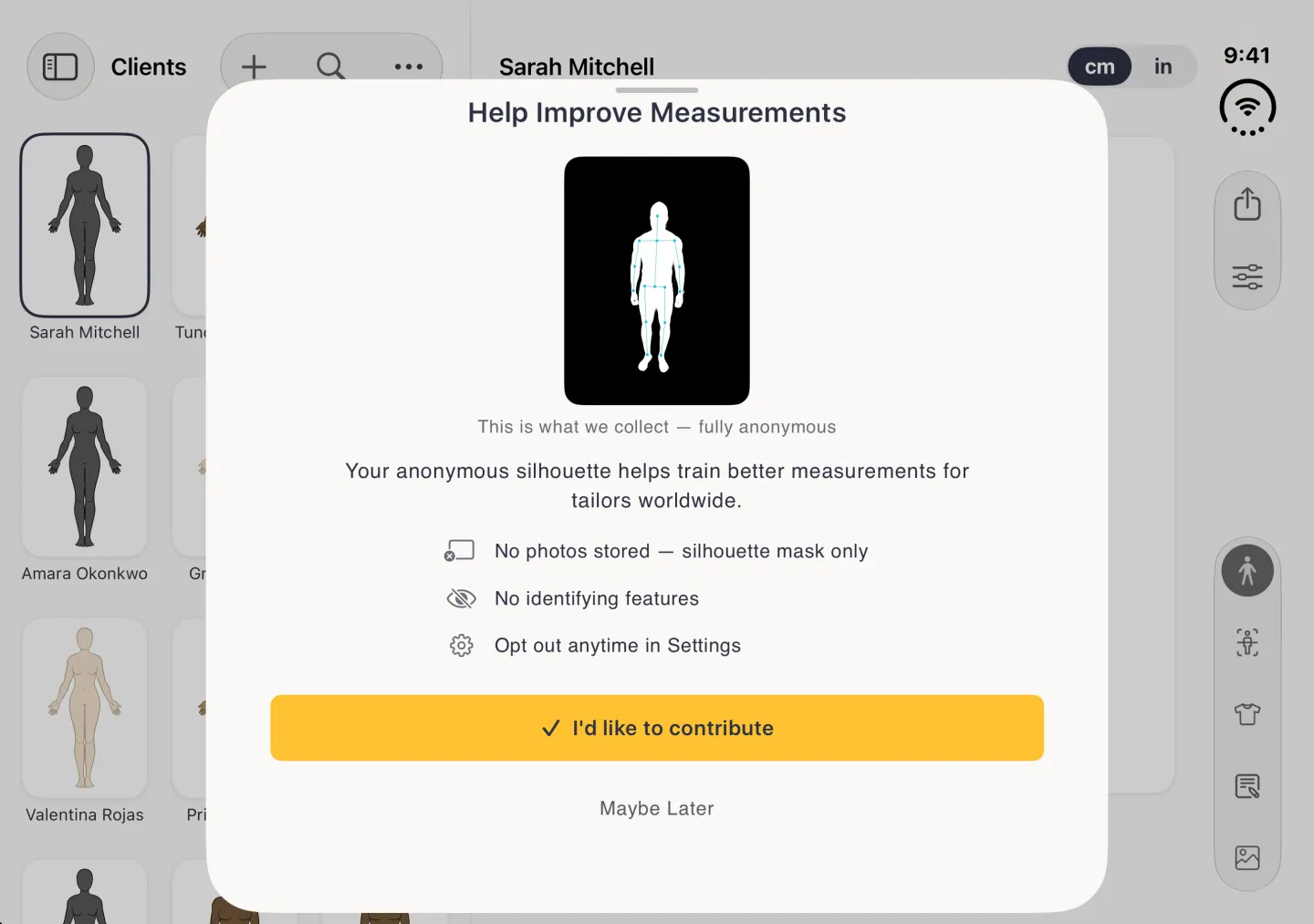 A Help Improve Measurements sheet with a grabber over the dimmed split view in landscape, showing a white body outline with blue pose points on a black card, the caption This is what we collect, fully anonymous, a line saying the anonymous silhouette helps train better measurements for tailors worldwide, three points reading No photos stored, silhouette mask only, No identifying features and Opt out anytime in Settings, a wide gold I'd like to contribute button and a Maybe Later link.
