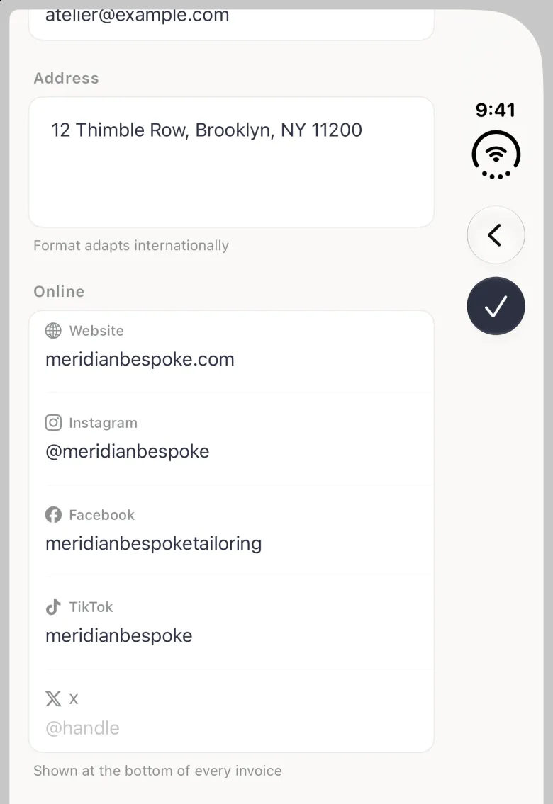 Business Profile on the closed iPhone Duo scrolled to the Online section, with the back and navy checkmark buttons in the vertical bar strip on the right edge: the end of the Email field at the top, Address 12 Thimble Row, Brooklyn, NY 11200 with Format adapts internationally, then Website meridianbespoke.com, Instagram @meridianbespoke, Facebook meridianbespoketailoring, TikTok meridianbespoke and an empty X field with the placeholder @handle, each label beside its platform logo, above the note Shown at the bottom of every invoice.