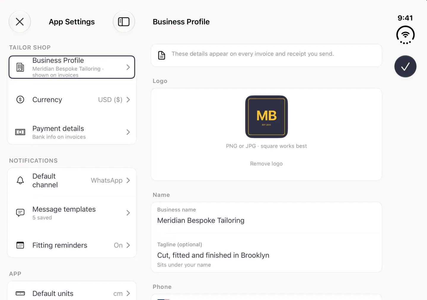 App Settings split view in landscape with Business Profile selected on the left and the Business Profile page on the right: a note that these details appear on every invoice and receipt you send, the square navy MB logo with PNG or JPG, square works best and a Remove logo link under it, the business name Meridian Bespoke Tailoring and the tagline Cut, fitted and finished in Brooklyn, and the Phone heading at the bottom, with a navy checkmark button in the vertical bar strip on the right edge.