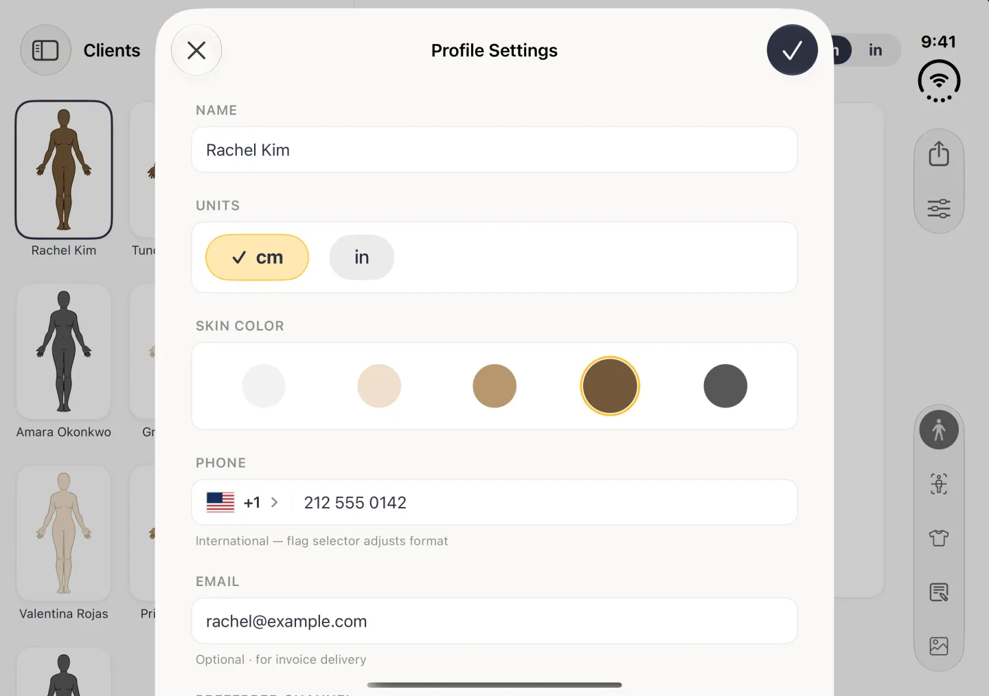Profile Settings as a card over the dimmed client view in landscape, with a cross at the top left and a navy checkmark at the top right, the name Rachel Kim under NAME, cm and in buttons under UNITS with cm ticked, five skin tone circles under SKIN COLOR with brown ringed in gold, then PHONE +1 212 555 0142 and EMAIL with an address.
