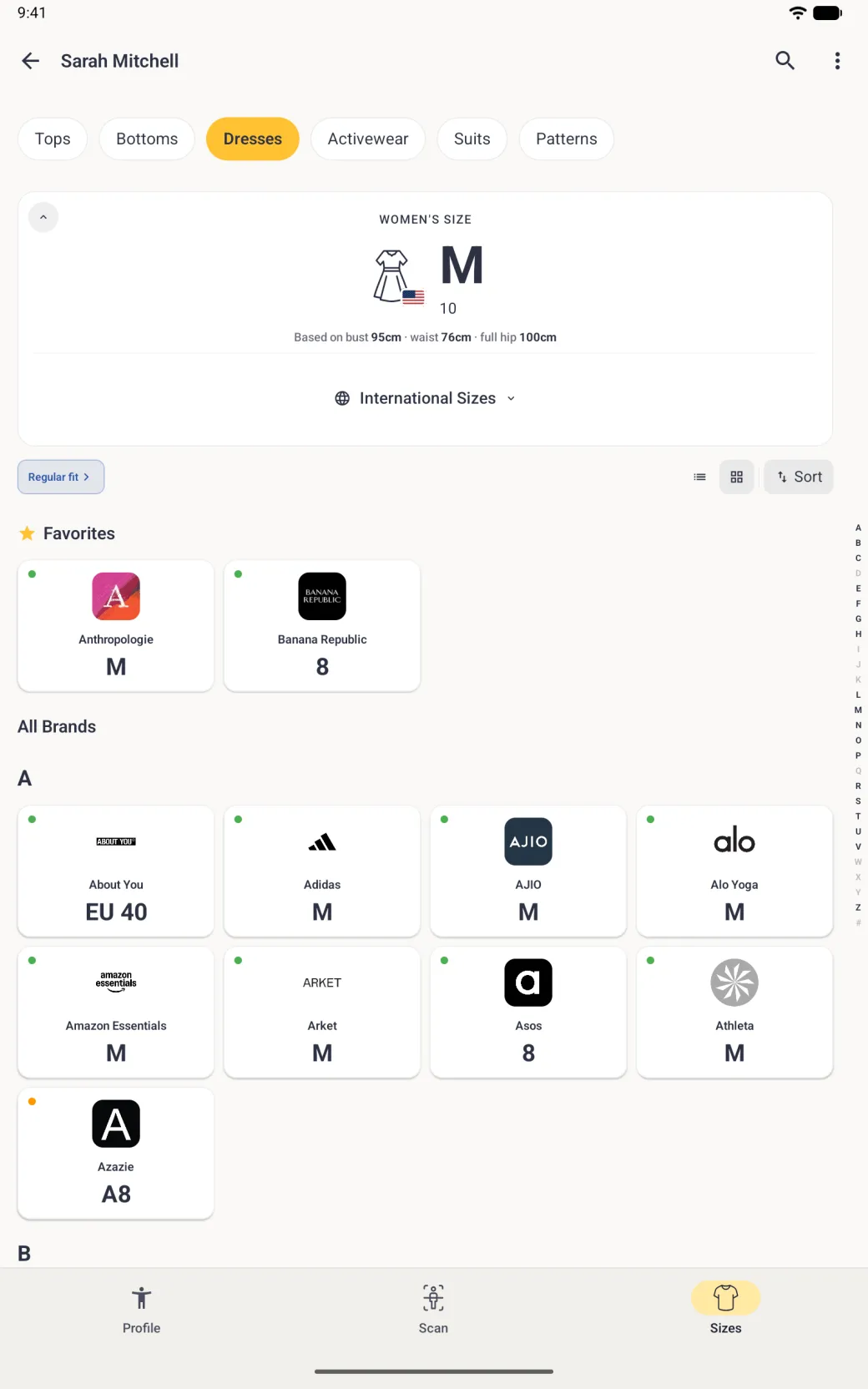 A Sizes tab in a four-column grid of brand logo cards, Favorites first, then All Brands under the heading A, About You, Adidas, AJIO, Alo Yoga, Amazon Essentials, Arket, Asos, Athleta and Azazie, each with a coloured dot and a size, with a thin alphabet index from A to Z and # running down the right edge.
