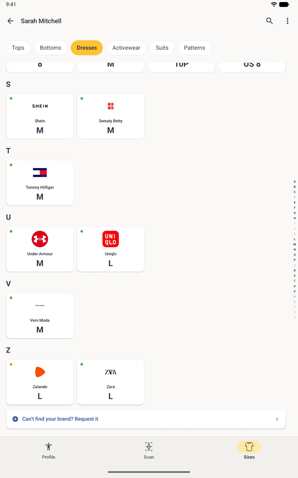 The end of the Sizes brand grid for Dresses, with the last cards of the R group cut off under the category chips, then the S, T, U, V and Z groups (Shein M, Sweaty Betty M, Tommy Hilfiger M, Under Armour M, Uniqlo L, Vero Moda M, Zalando L with an orange dot and Zara L), followed by a full-width white row with a blue plus icon reading Can't find your brand? Request it and a chevron, and the alphabet index at the right edge with Z in gold.