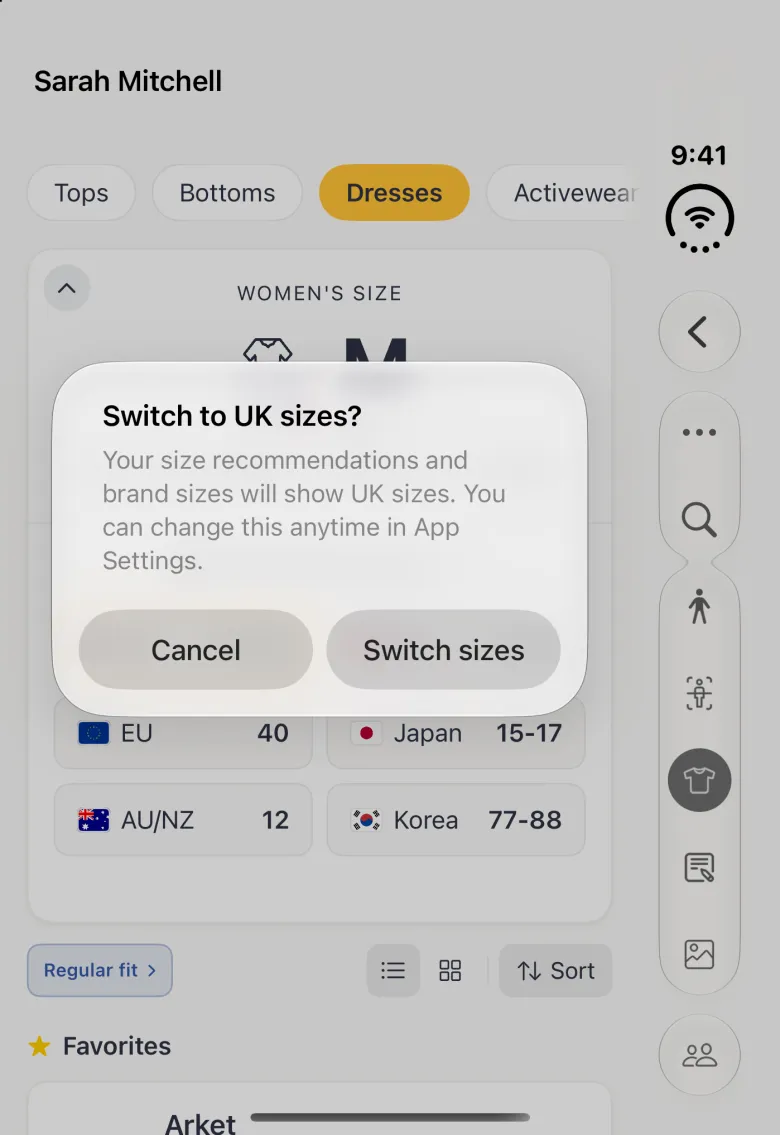 A system alert over the dimmed Sizes section on the closed Duo, titled Switch to UK sizes? explaining that size recommendations and brand sizes will show UK sizes and can be changed in App Settings, with Cancel and Switch sizes buttons side by side; the vertical bar strip on the right is dimmed too.