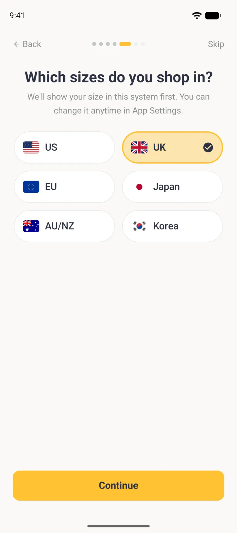 Which sizes do you shop in? step under seven page dots, fifth dot active, with the line We'll show your size in this system first. You can change it anytime in App Settings, six pill buttons in two columns for US, UK, EU, Japan, AU/NZ and Korea, each with its flag, UK filled pale gold with a gold border and a navy tick, above a gold Continue button.