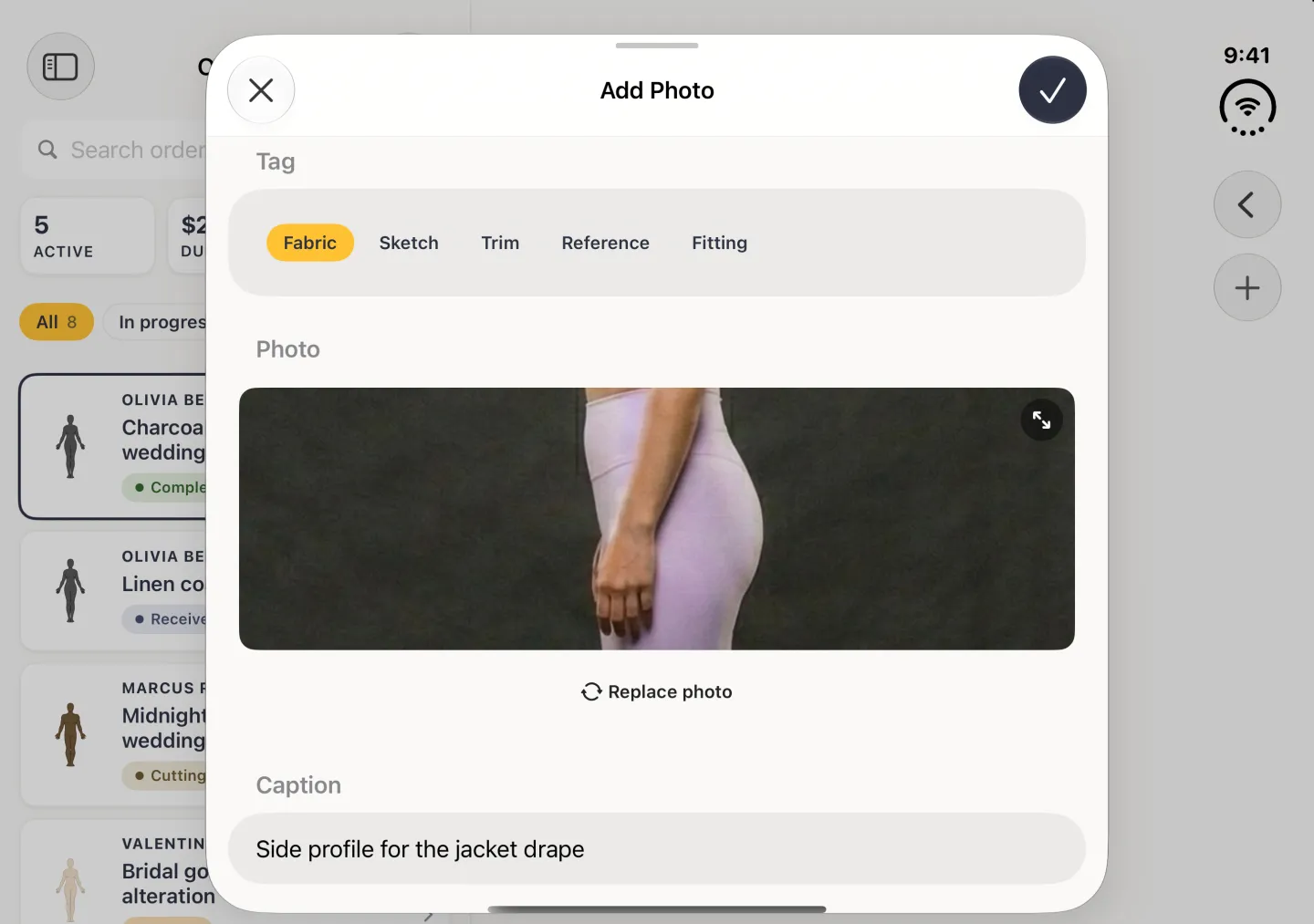 Add Photo sheet in landscape with the round tick at the top right now solid navy, the Fabric tag selected, a side-profile body photo filling the wide preview with an expand button in its corner, a Replace photo link below it, and a caption reading Side profile for the jacket drape.